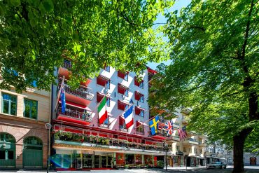 Exterior of Hotel Rival on Mariatorget in Södermalm, Stockholm, an LGBTQ+ welcoming boutique hotel with international flags flying above its entrance