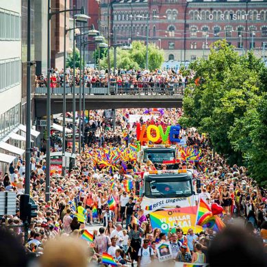 A Pride parade moving along a road in Stockholm