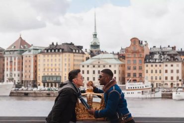 Two gay men kiss by the waterfront in Stockholm