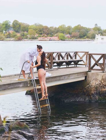 Two women kiss while getting out of a waterway near Hotel J. Stockholm work-life balance.