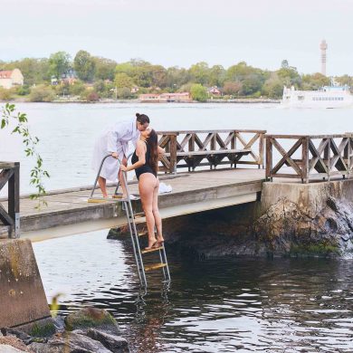 Two women kiss while getting out of a waterway near Hotel J. Stockholm work-life balance.
